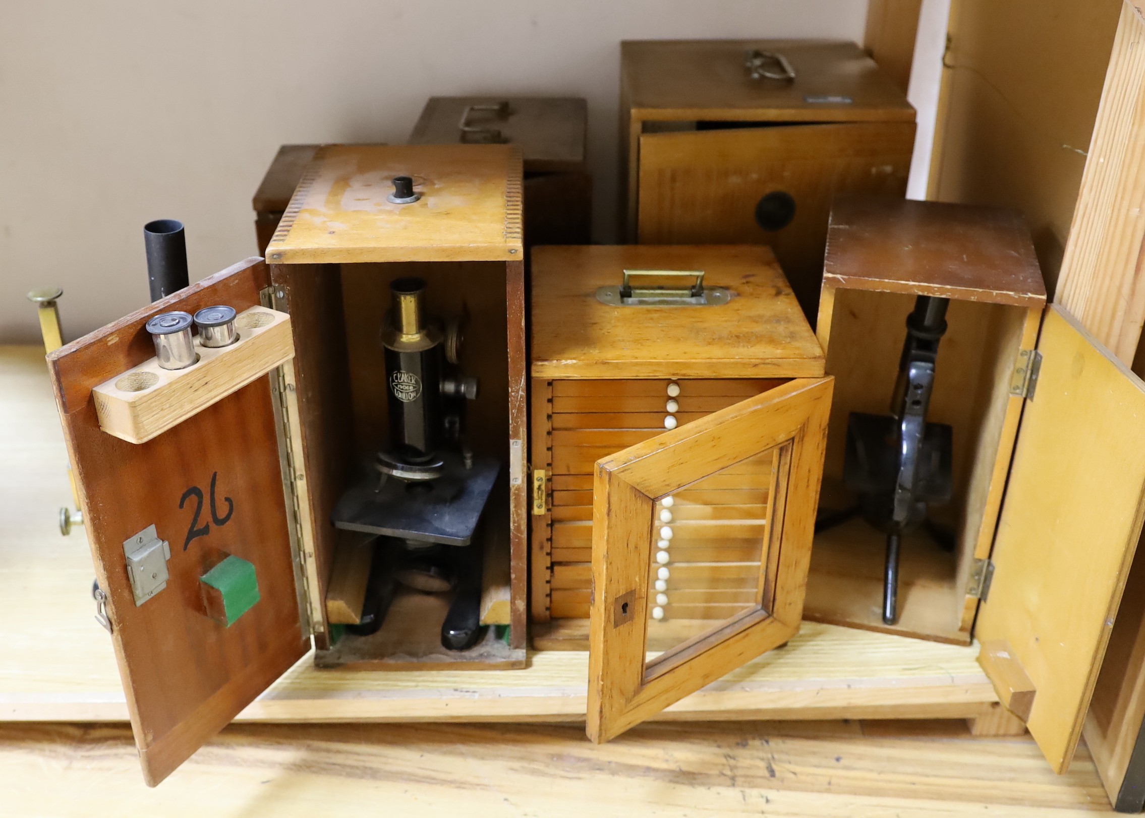 Five cased microscopes, another uncased and a pine microscope slide cabinet, latter 25.5 cm height